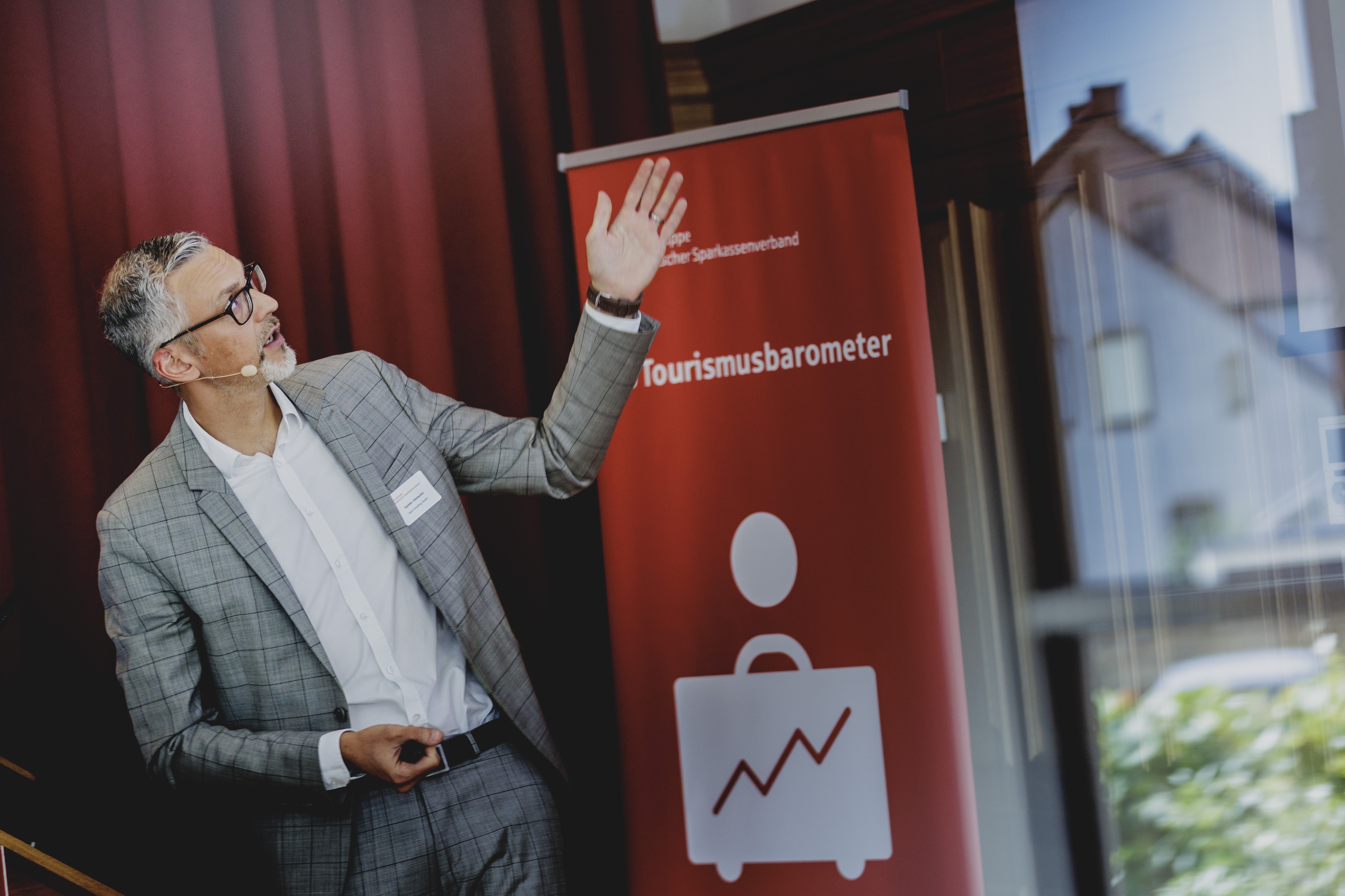 Mann präsentiert Sparkassen-Tourismusbarometer