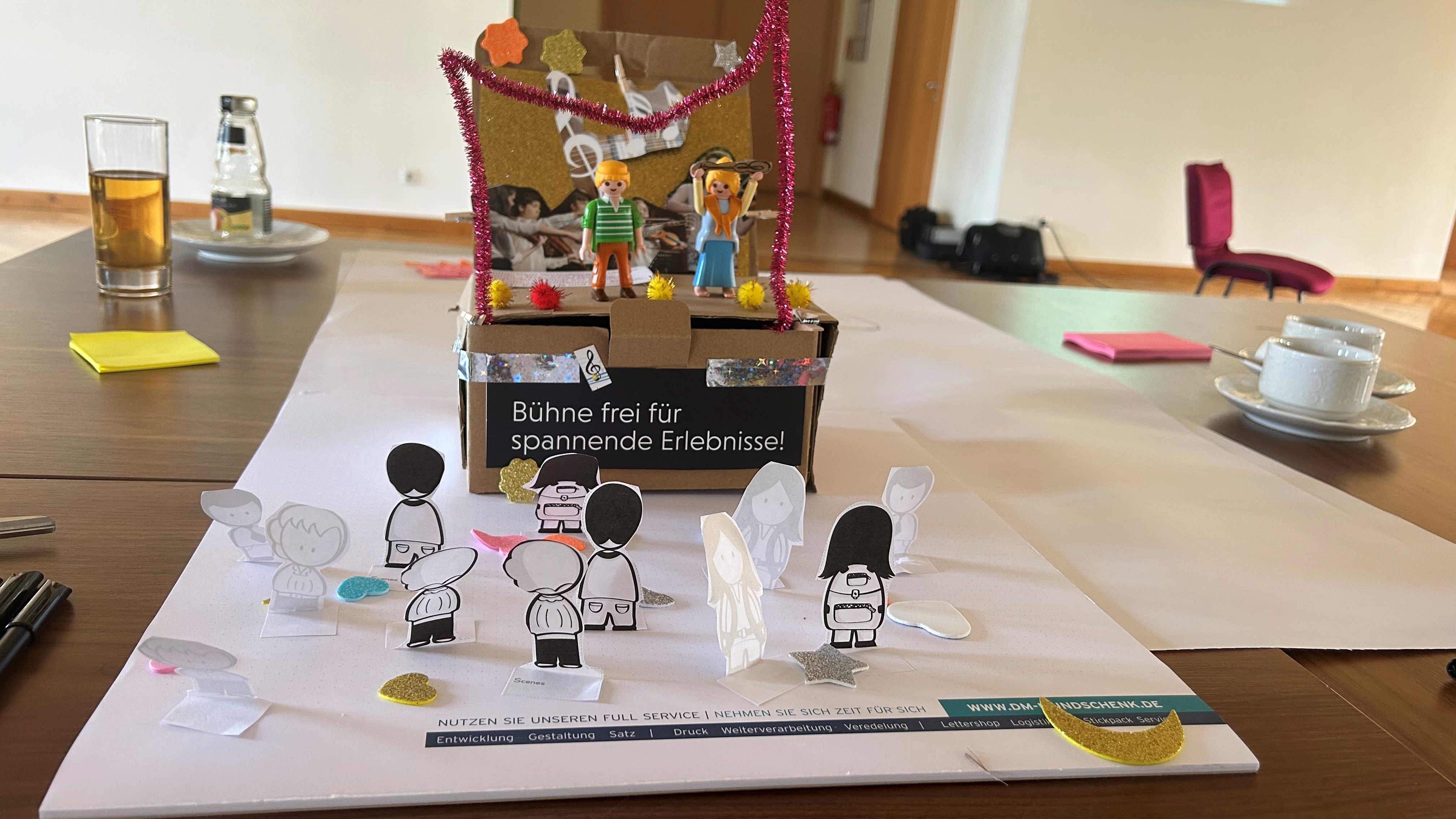 Playmobil Figuren auf einer Bühne aus Pappkarton