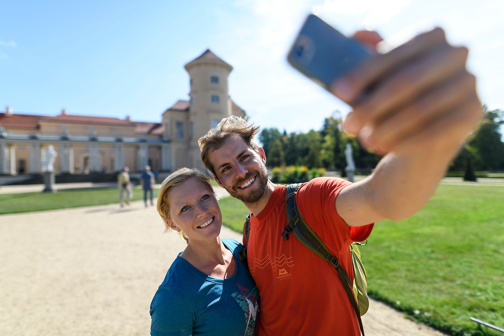 Zwei Spaziergänger machen Selfie vor dem Schloss Rheinsberg