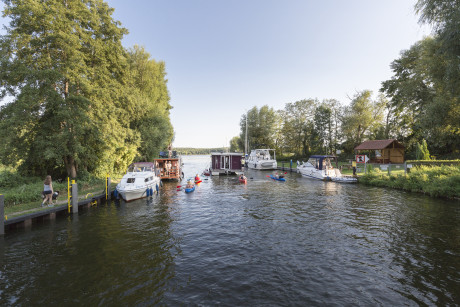 Hausboottour im Sommer im Ruppiner Seenland, Boote, Kanus und Hausboot auf dem Wasser am Kanal