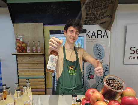 Lukas Kunzmann Gründer Kara-Limo an seinem Stand auf der grünen Woche 2024, hält in einer Hand eine Flasche der Kara Limo und hält mit der anderen Hand den Daumen nach oben