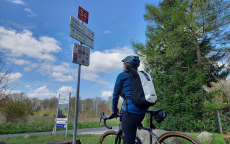 Foto von Fahrradfahrerin an einem Knotenpunkt-Wegweiser
