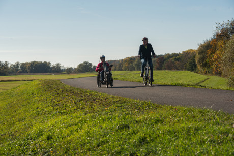 Radfahrer und Handbiker auf einem Radweg unterwegs