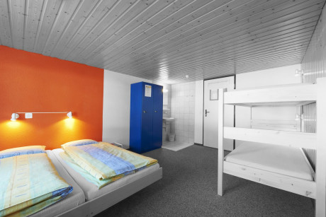 Foto von Hostelzimmer mit Doppelbett und Doppelstockbett