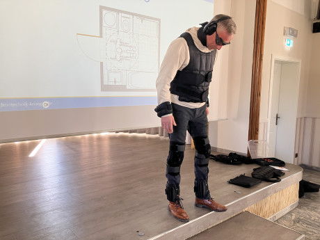 Mann in Alterssimulationsanzug versucht Stufe zu überwinden
