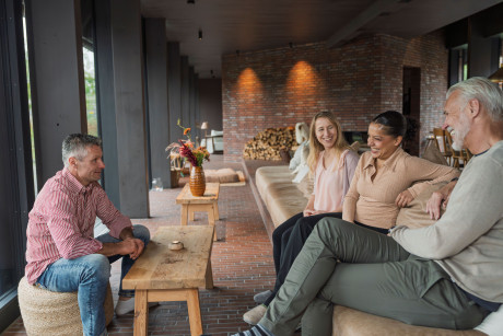 Michelberger Farm im Spreewald, Menschen sitzen auf Couch und Hocker und reden miteinander