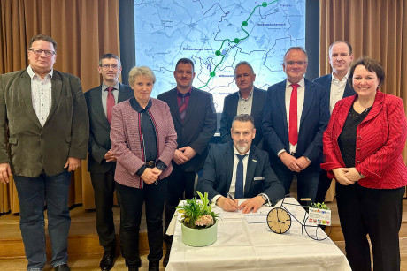 Umringt von den Projektpartnern setzt Bürgermeister Hendrik Sommer für die Stadt Prenzlau seine Unterschrift unter die Vereinbarung.