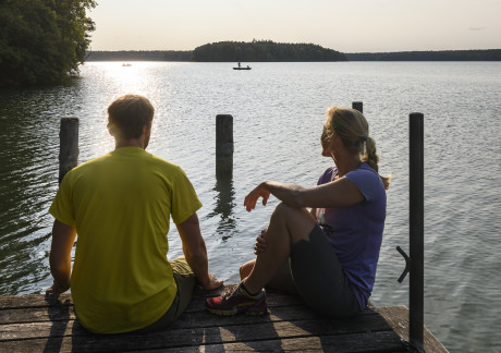 Foto von zwei Personen auf einem Bootssteg in der Dämmerung