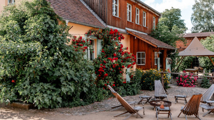 Gartenmöbel aus Holz stehen im Hof des Gut Leben Landresorts