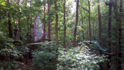 Besuchende balancieren auf Seilen und Emporen des Kletterparks Grünheide