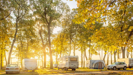 Campingmobile und Wohnwagen vor der aufgehenden Sonne auf dem Campingplatz Sanssouci in Potsdam