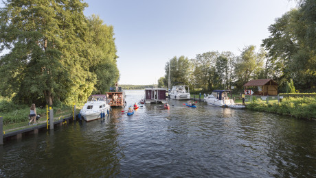 Hausboottour im Sommer im Ruppiner Seenland, Boote, Kanus und Hausboot auf dem Wasser am Kanal