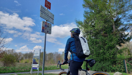 Foto von Fahrradfahrerin an einem Knotenpunkt-Wegweiser