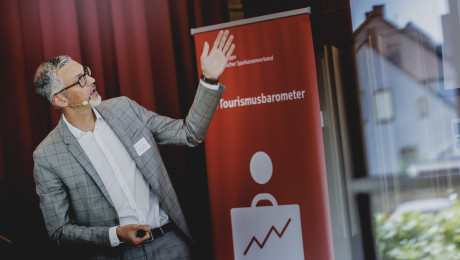 Mann präsentiert Sparkassen-Tourismusbarometer