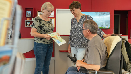 Ein Mann im Rollstuhl und eine Frau in der Touristinformation Prenzlau