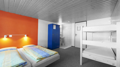 Foto von Hostelzimmer mit Doppelbett und Doppelstockbett