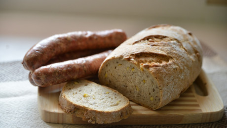 Foto von Wurst und Brot angeschnitten auf einem Holzbrett