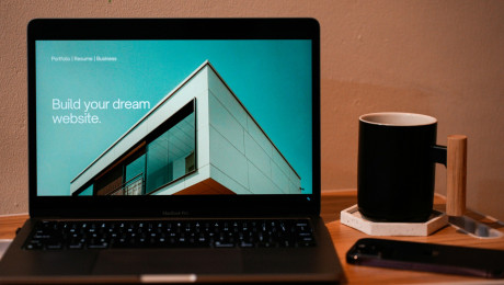 Laptop zeigt Webseite mit dem Titel "Build your dream website"