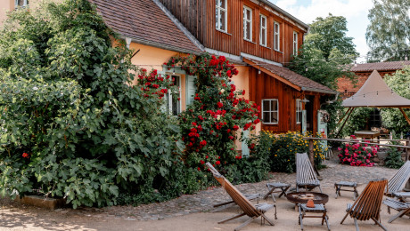 Gartenmöbel aus Holz stehen im Hof des Gut Leben Landresorts
