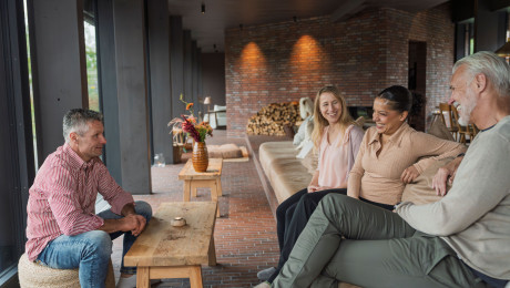 Michelberger Farm im Spreewald, Menschen sitzen auf Couch und Hocker und reden miteinander