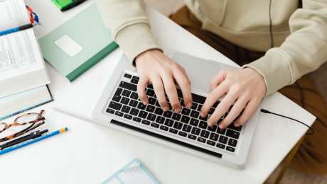 Schreibtisch mit Tastatur, Buch, Stiften und Brille