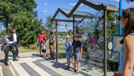 Kinder stehen an einer Bushaltestelle