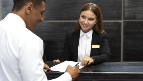 Ein Gast checkt bei der Hotelrezeption ein