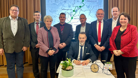 Umringt von den Projektpartnern setzt Bürgermeister Hendrik Sommer für die Stadt Prenzlau seine Unterschrift unter die Vereinbarung.