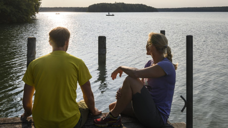 Foto von zwei Personen auf einem Bootssteg in der Dämmerung